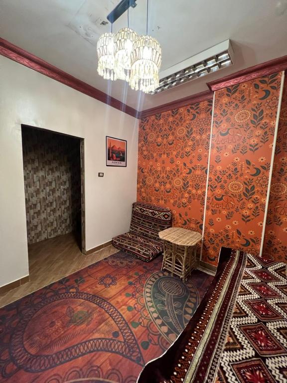 a living room with orange walls and a chandelier at Aswan House center in Aswan