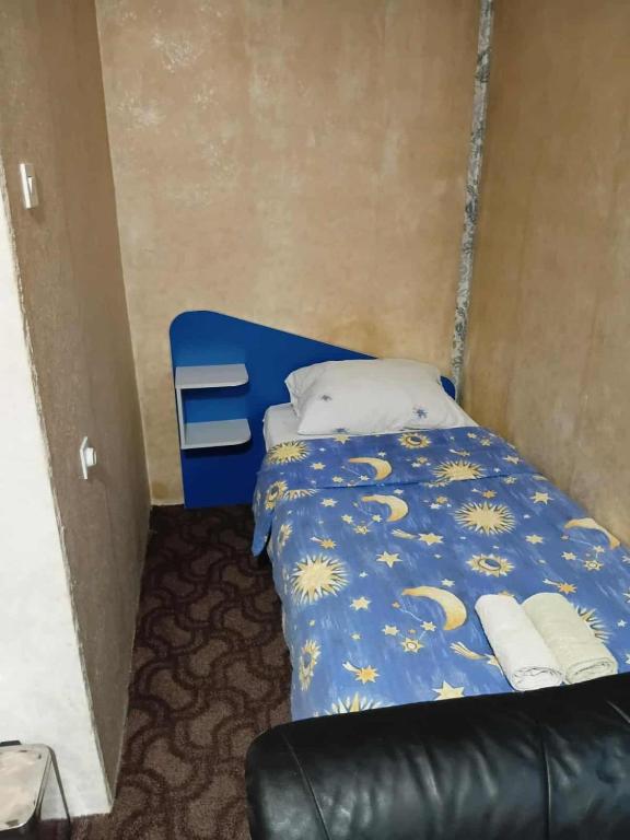 a small bed in a room with a blue and yellow comforter at KONAK kod ODISEJE 2 in Moševići