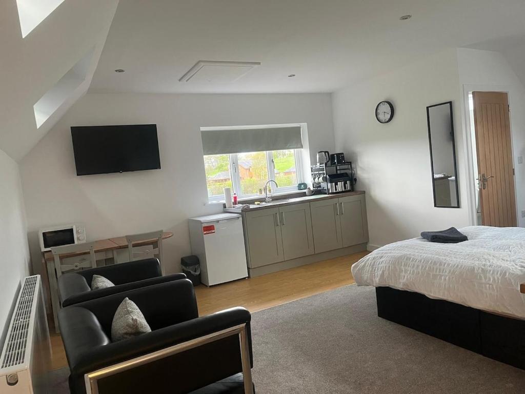 a bedroom with a bed and a kitchen with a sink at Oak Field View - Self Contained Studio in Scotby