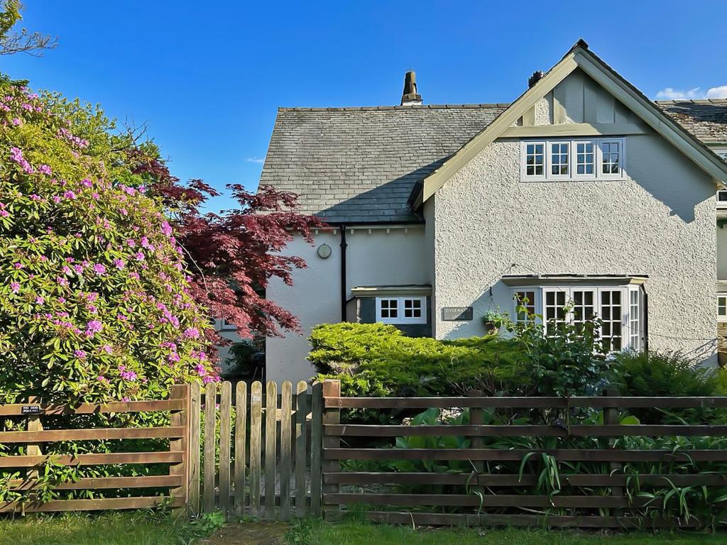 a white house with a wooden fence at Overwater Lodge in Bassenthwaite Lake