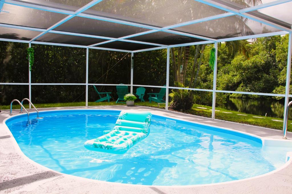 een zwembad met twee ligstoelen in het water bij NO EXTRA FEES! Heated pool, Rods, BBQ, Fire Pite, 8 PAX, 2BR, 3BA in North Fort Myers