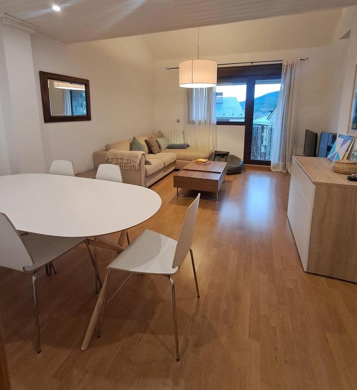 a living room with a white table and chairs at Casa los Rebecos in Villanúa