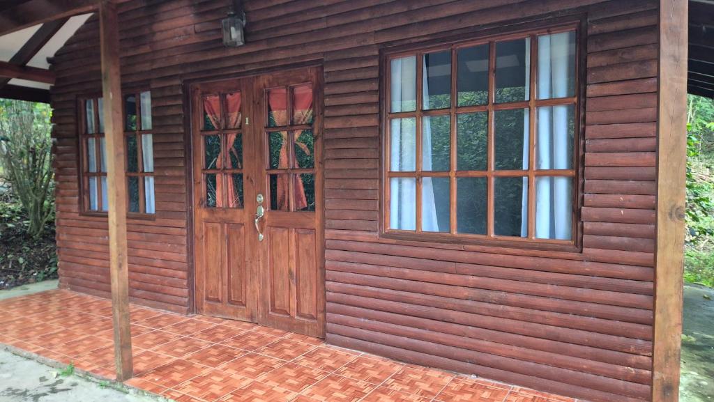 Casa de madera con 2 puertas y ventanas en Cabañas La Catarata, en Higueronal