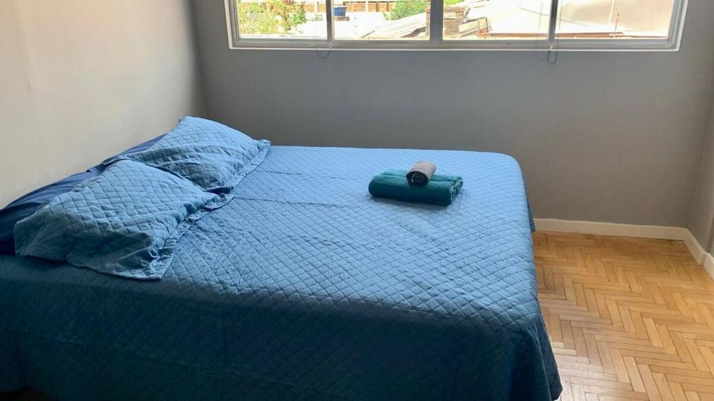 Apt recém reformado في فوز دو إيغواسو: غرفة نوم بسرير لحاف ازرق ومخدة