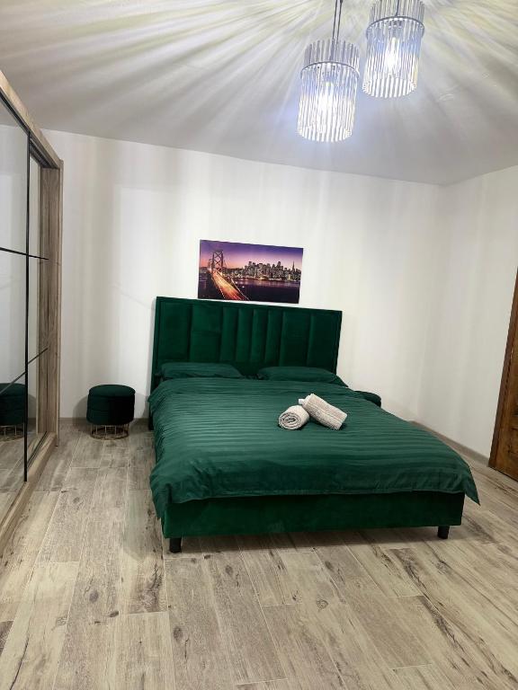 a bedroom with a green bed with two hats on it at Studio Bella Centru 26 in Craiova