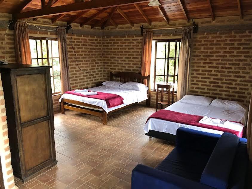 a bedroom with two beds and a couch in it at Finca la Albania in Circasia