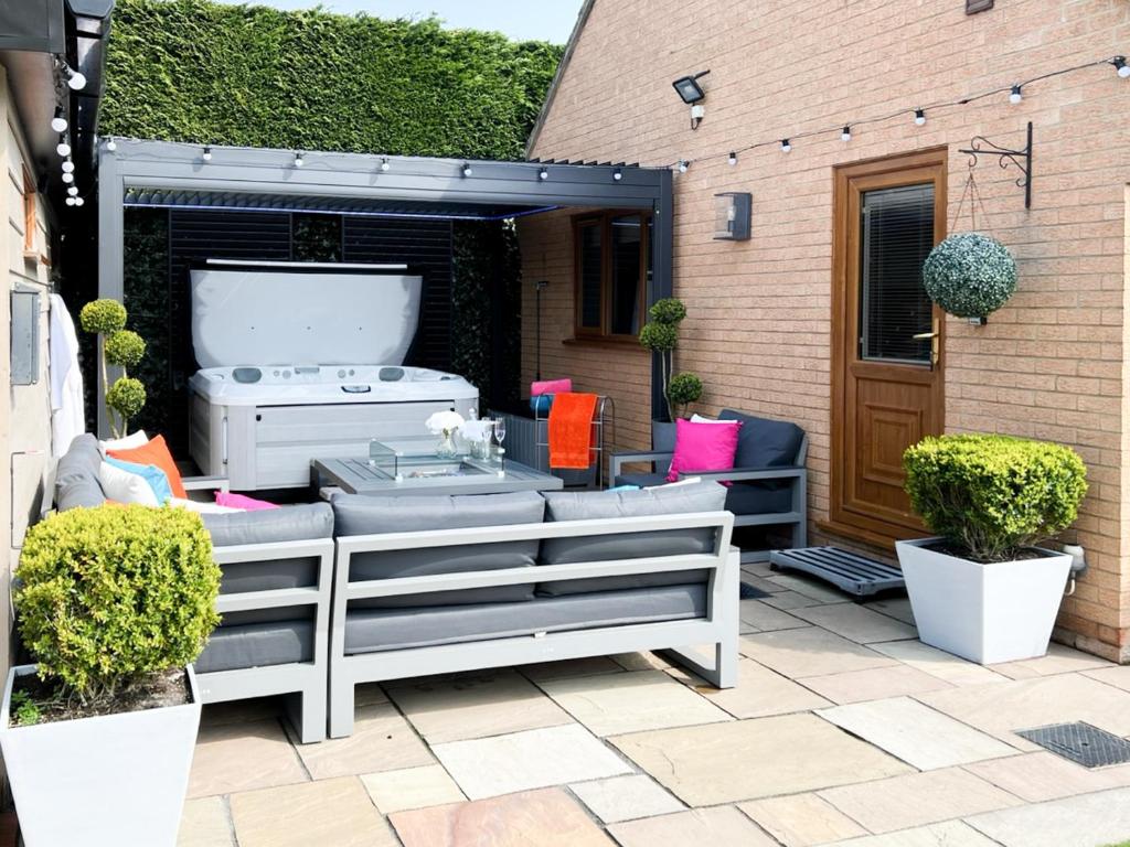a patio with a grill and some bushes at Rivendell Lodge - Cottage in East Winch