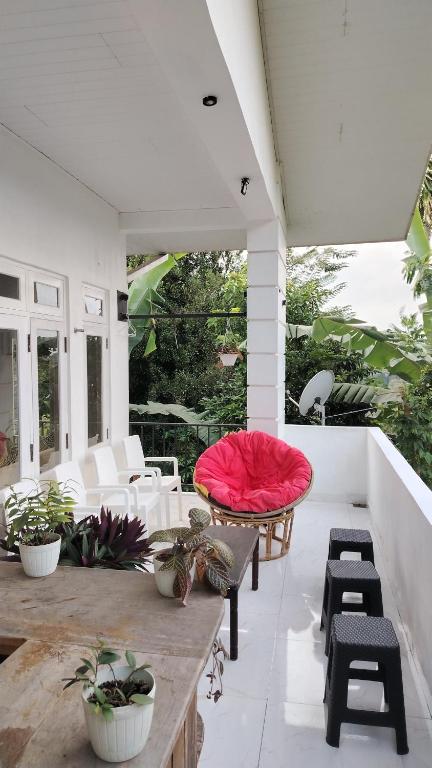 a patio with a table and chairs and a red cushion at Kandy Home stay - Haloluwa in Katugastota
