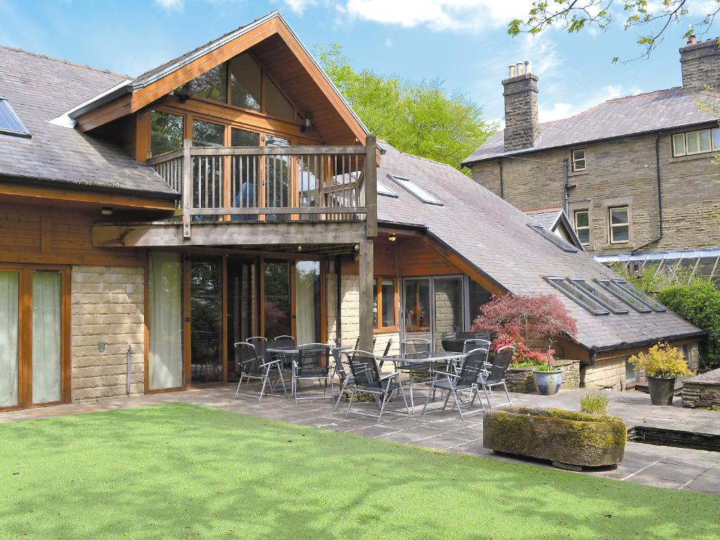 ein Haus mit einer Terrasse und Stühlen in der Unterkunft Moorecroft in Buxton