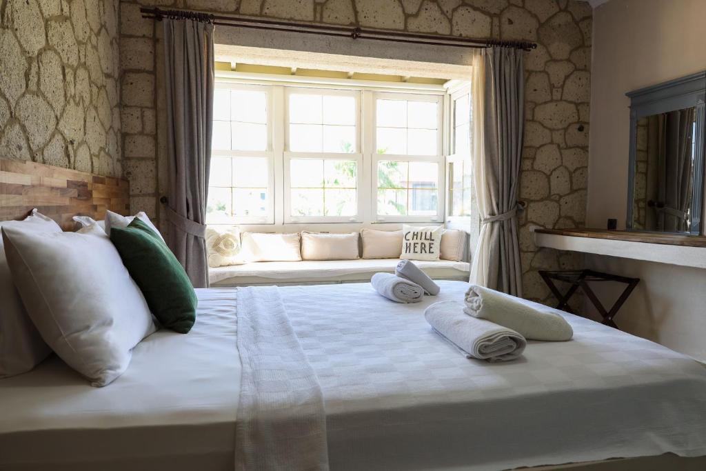 a bedroom with a large white bed with towels on it at naya port in Alacati