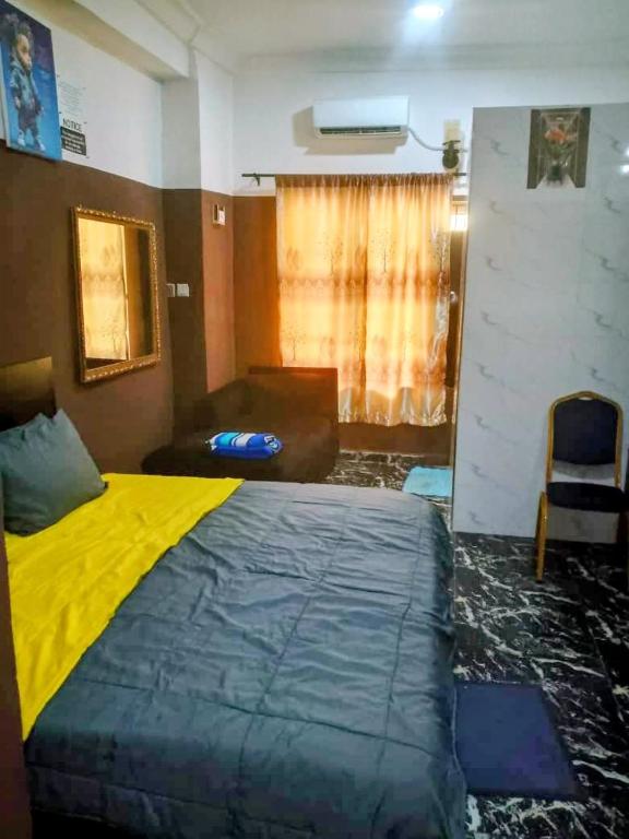 a bedroom with a large bed with a yellow blanket at Short Let Apartments in Lagos Business School Lekki Ajah in Lekki