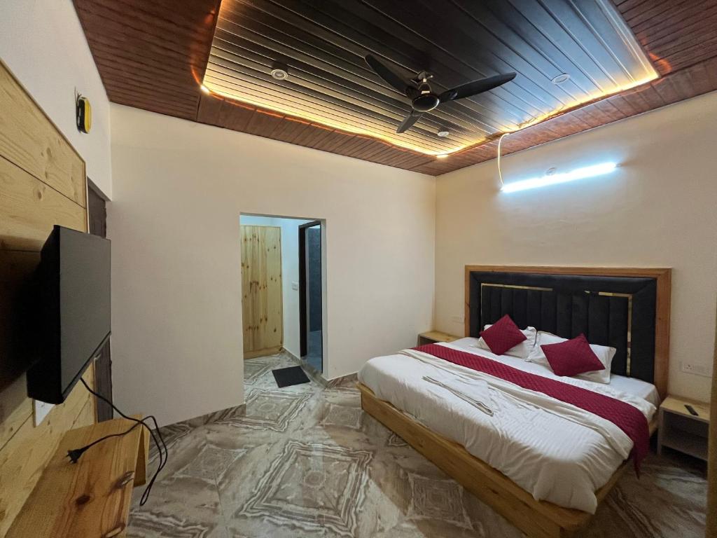 穆索里Rana farm house的一间卧室，里面有一张床和一台平板电视