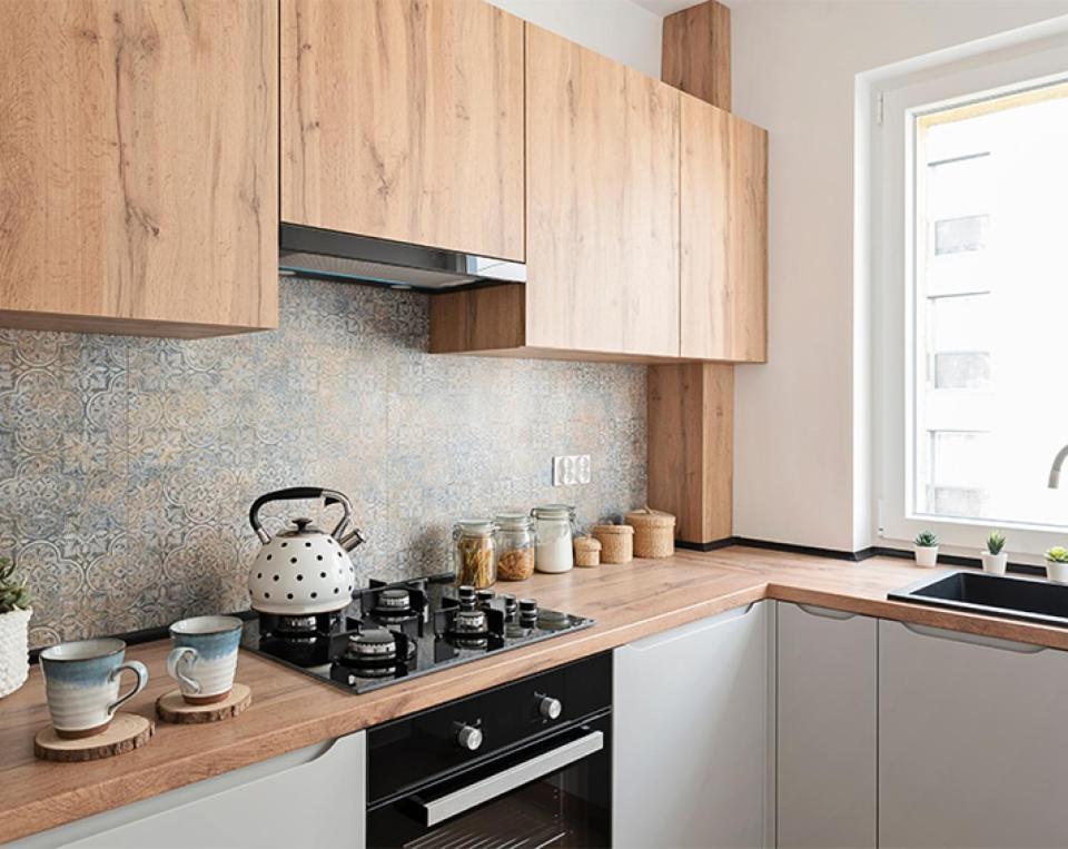 a kitchen with wooden cabinets and a stove top oven at Port la goulette in La Goulette