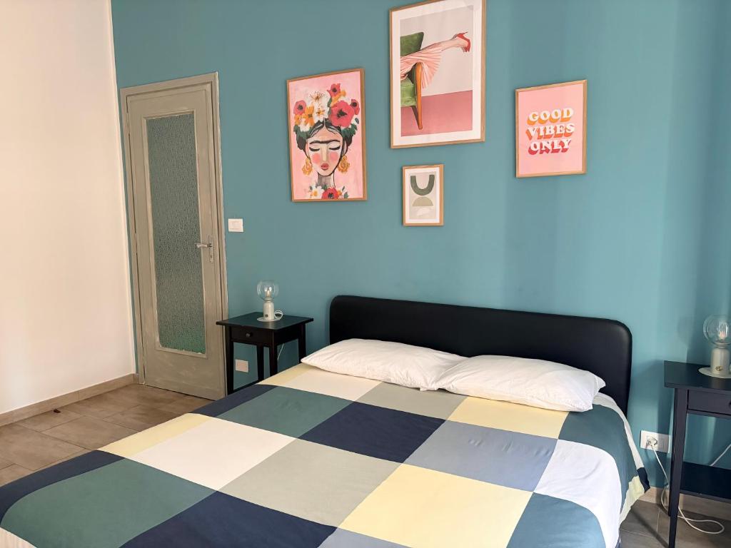 a bedroom with a bed with a blue wall at Jaky Maison Torino, Cozy & Modern Stay in Turin