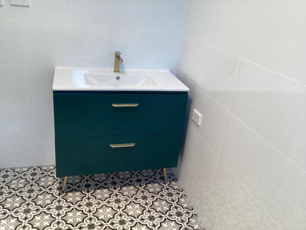a bathroom with a blue cabinet and a sink at Malanda Falls Retreat in Malanda