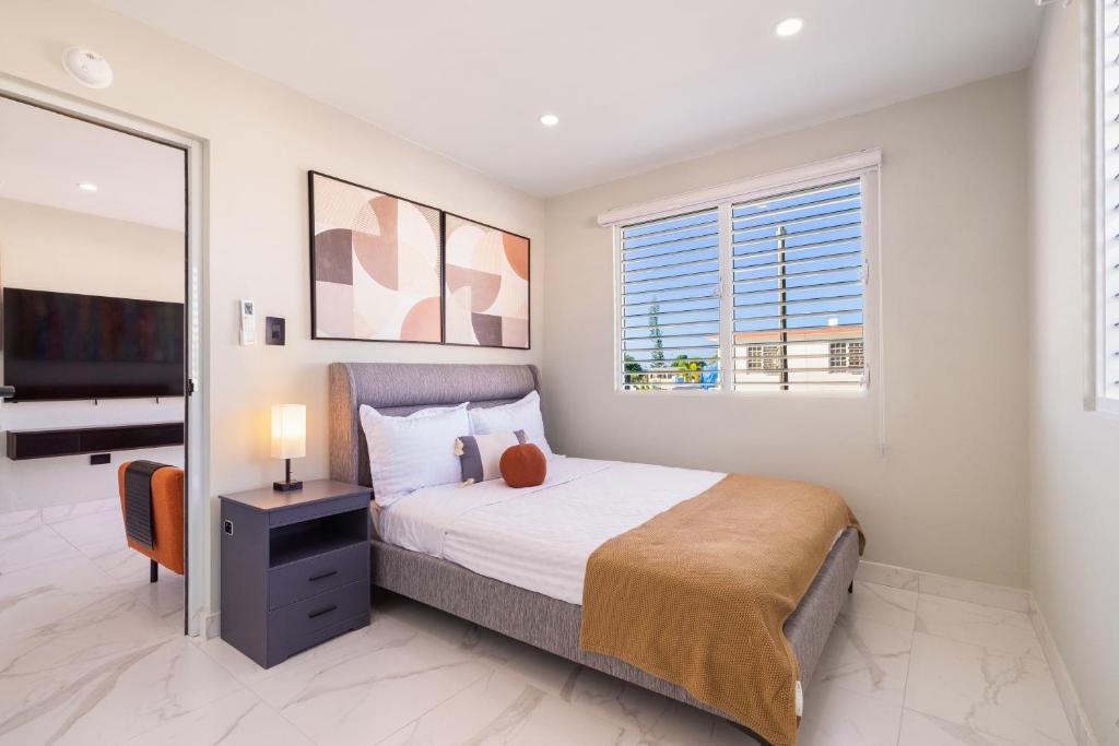 une chambre avec un lit et une télévision à écran plat dans l'établissement SunJoy Gateway Lux 2 bedroom House by PH, à Carolina