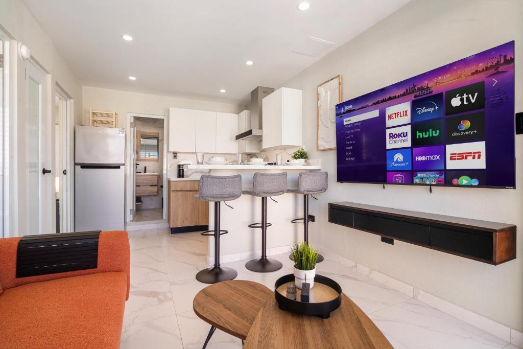 a kitchen with a large tv on the wall at San Juan Gateway Lux 2 bedroom House by PH in Carolina
