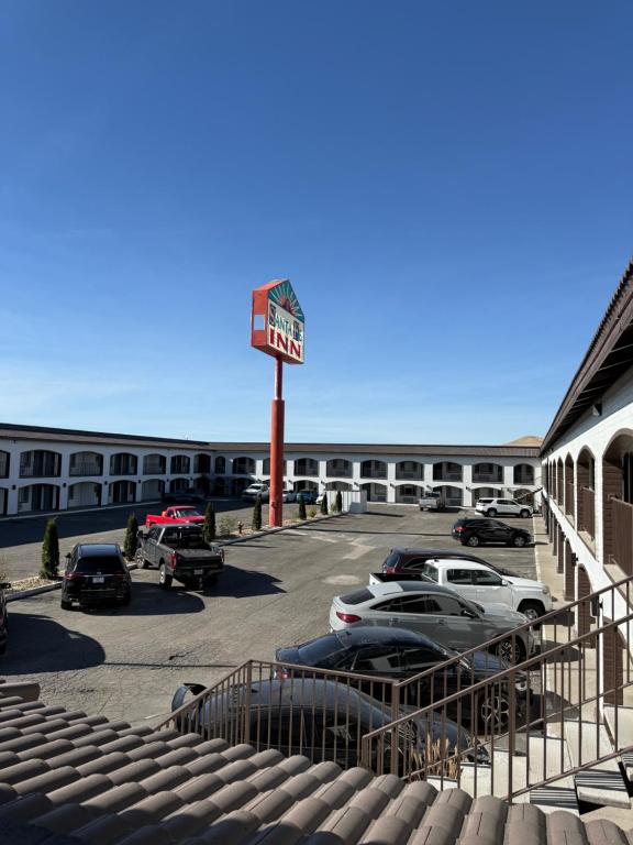 een parkeerplaats met een hotelbord en geparkeerde auto's bij Rodeway Inn - SFI Winnemucca in Winnemucca