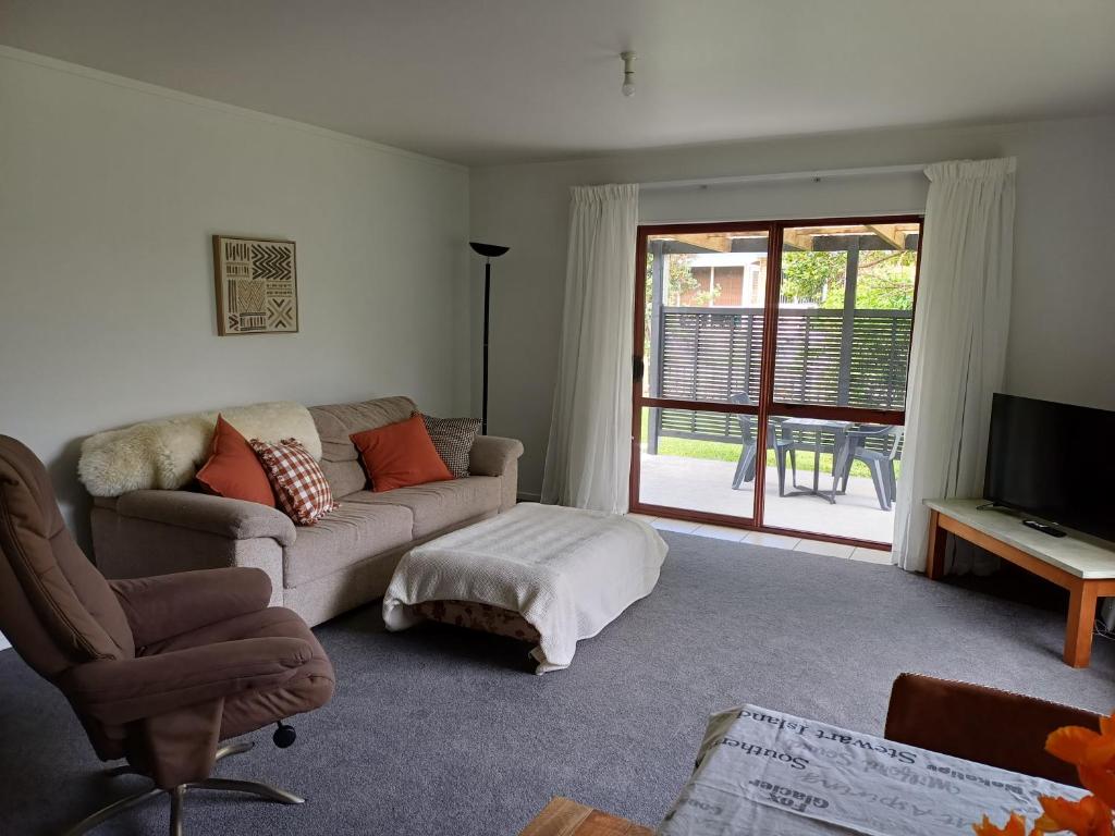 a living room with a couch and a tv at House in Restful Setting in Whangarei