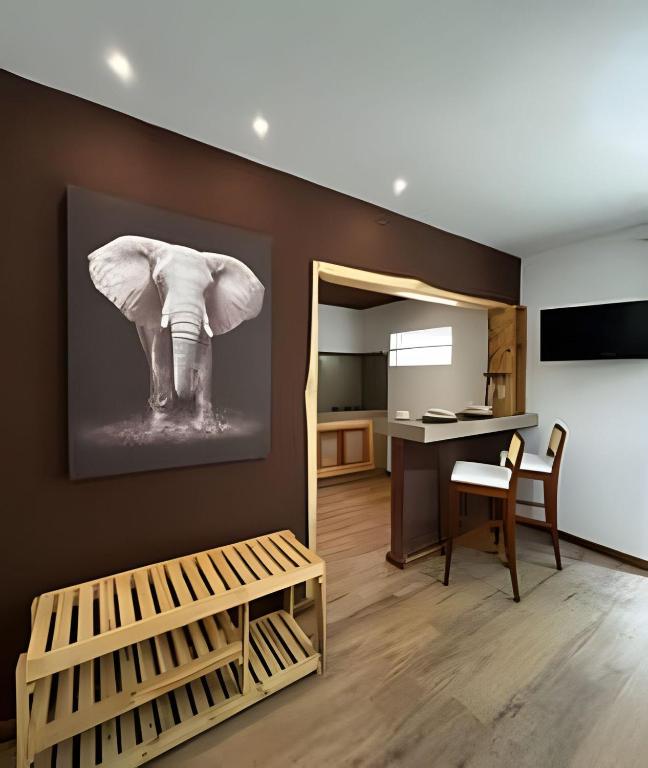 une pièce avec une peinture d'éléphant sur le mur dans l'établissement Flat Ruanda para casal em meio à natureza!, à Nova Friburgo