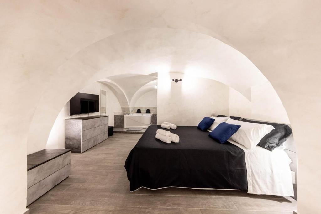 una camera da letto con un letto e un bagno con un lavandino di Volcano Home a Catania