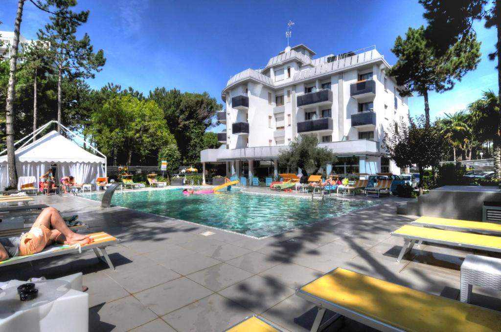 una persona sdraiata su una poltrona di fronte alla piscina dell'hotel di Hotel Franz a Bibione