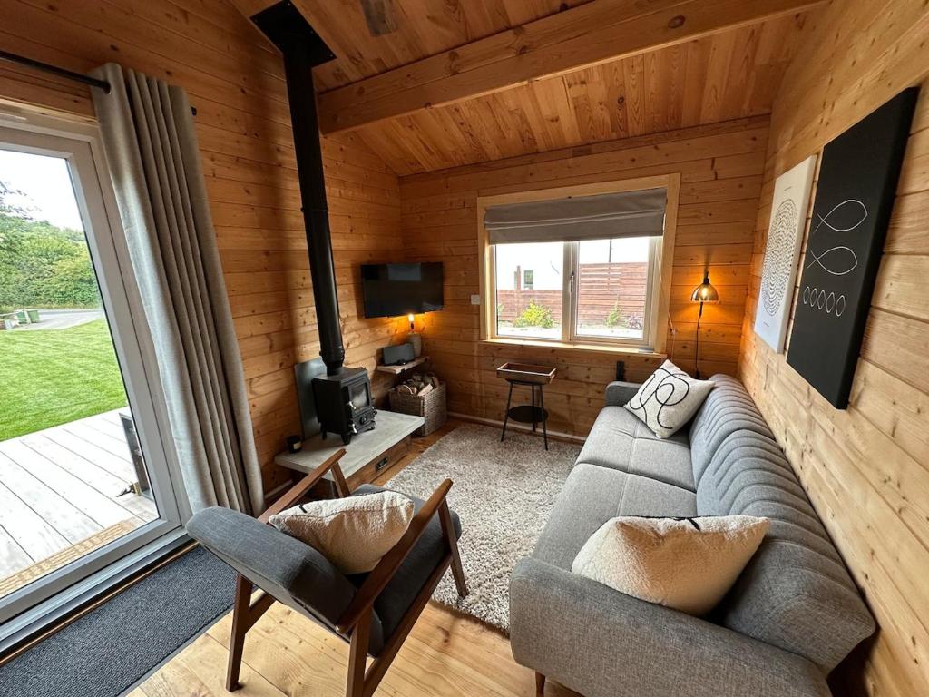 a living room with a couch and a tv at The Cabin 6 minutes from the Eurotunnel in Folkestone