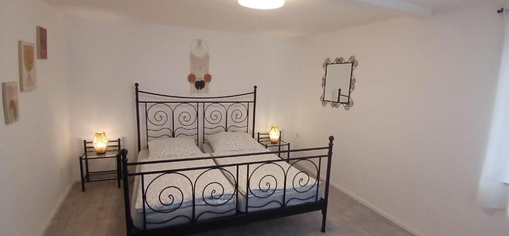 a bedroom with a black bed with two lights on it at Ferienwohnung Alte Scheune in Westerburg