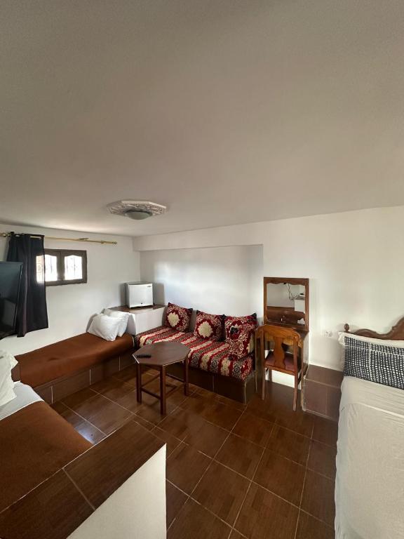 a living room with a couch and a bed at Nouara Appart'Hotel in Chefchaouen