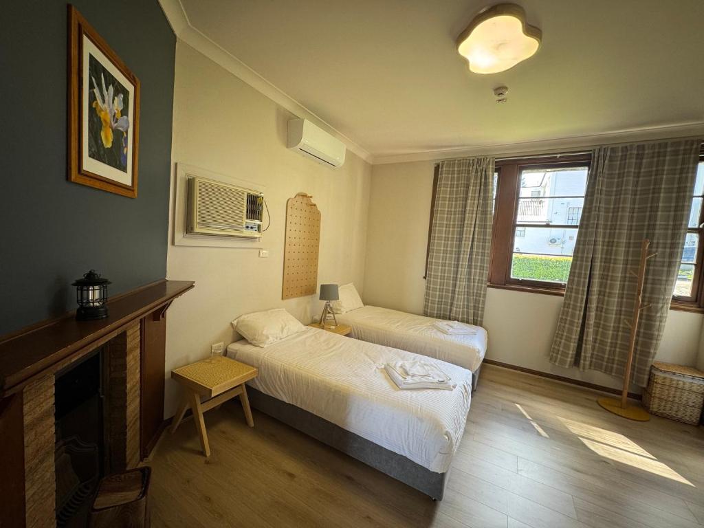 a bedroom with two beds and a fireplace at Mowbray Park Holidays in Picton
