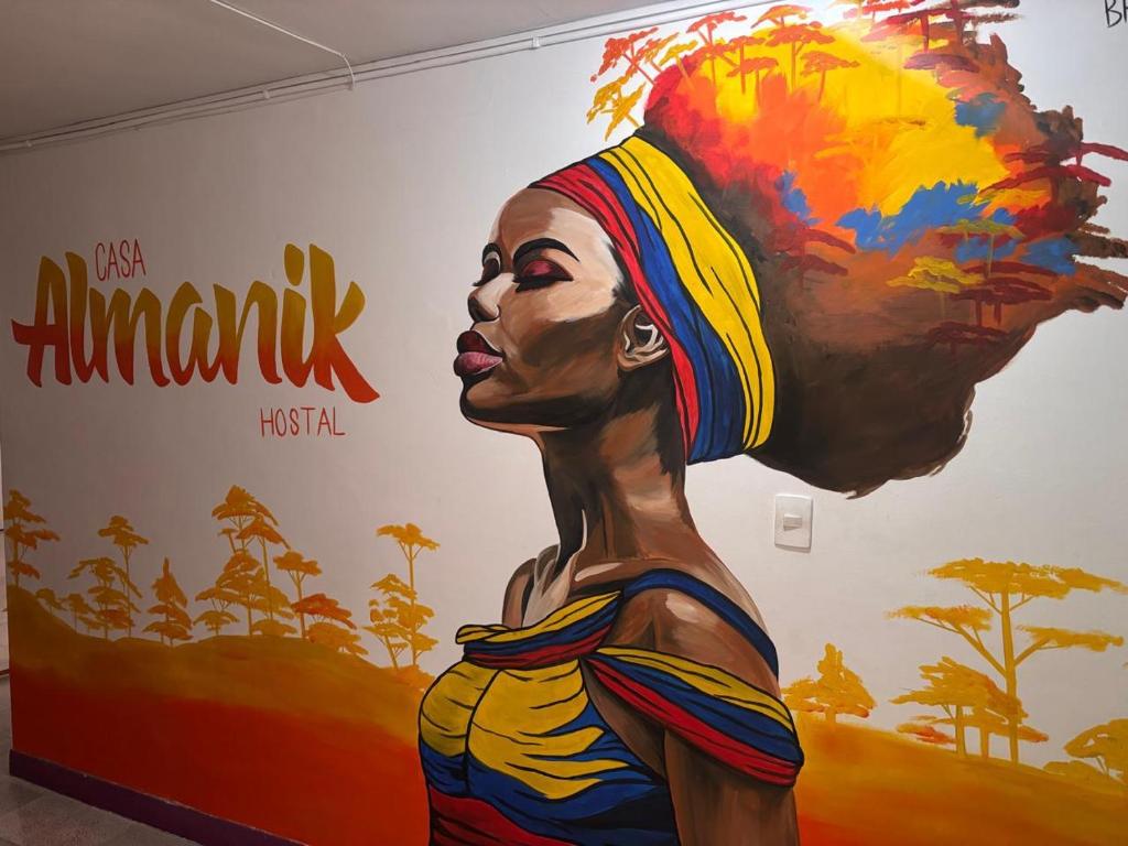 a painting of a woman in front of a wall at Casa Almanik Hostel in Medellín