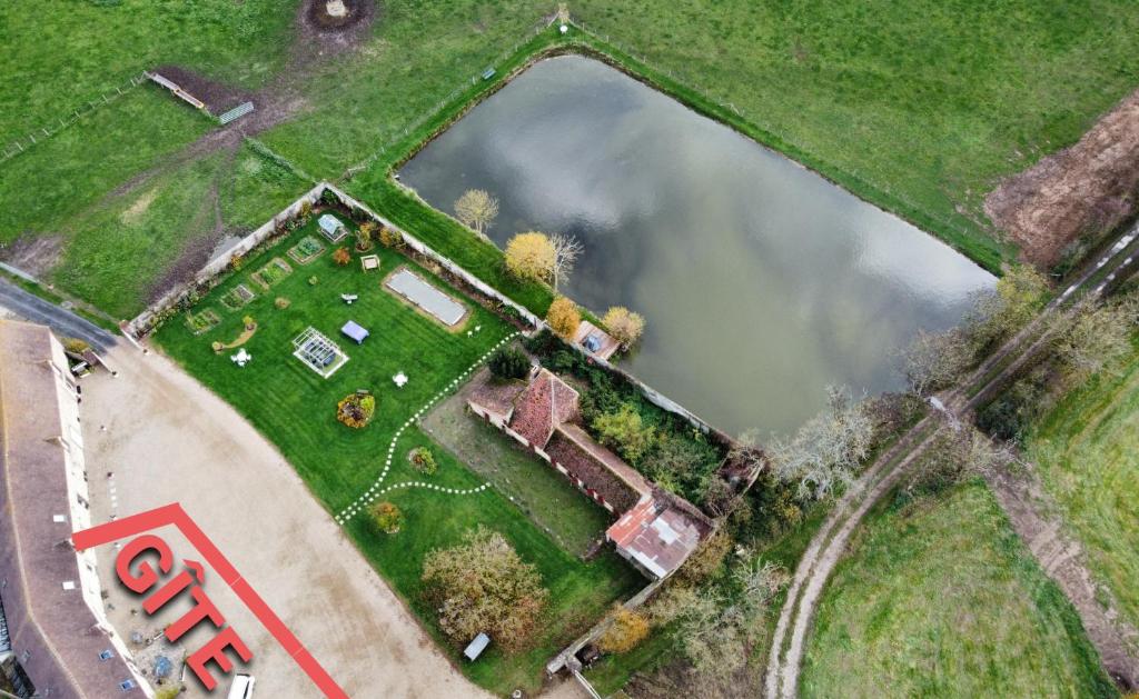 an aerial view of a house with a lake at La Gravardière, Nature & Pêche, à 5min de la ville in Belhomert-Guéhouville