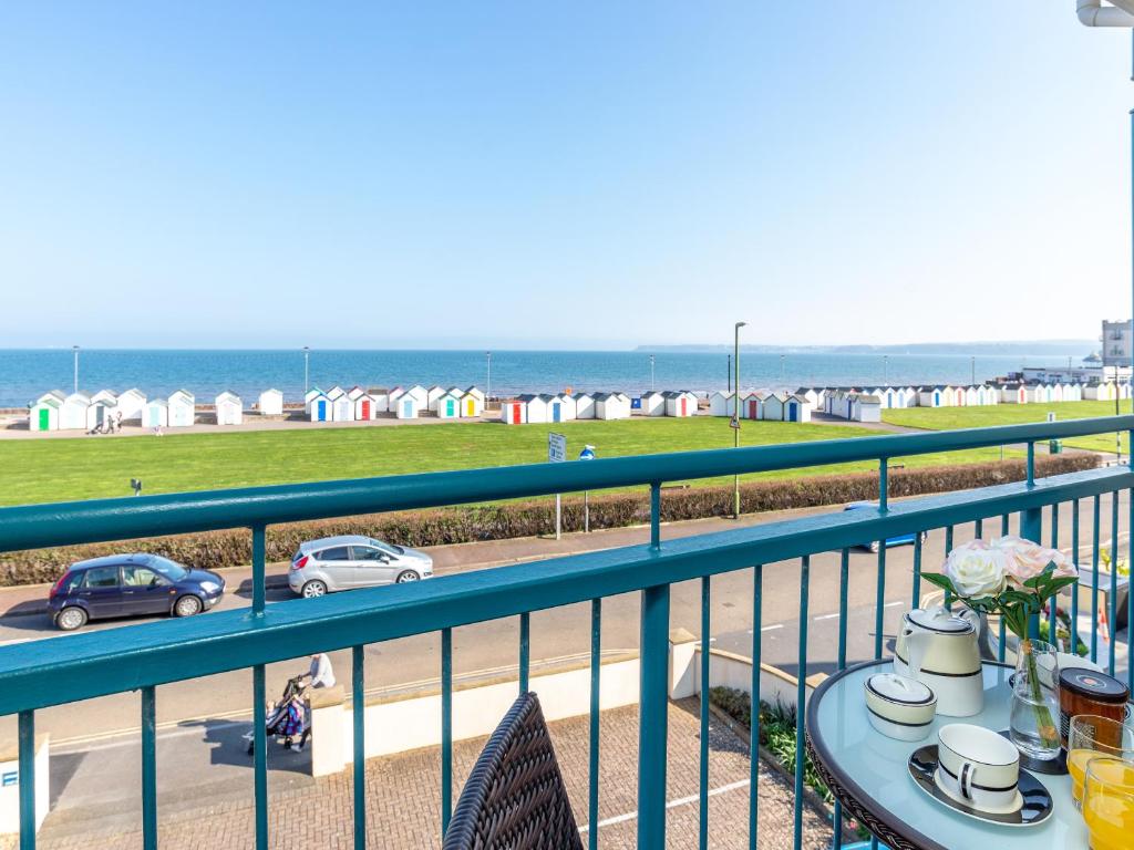 einen Balkon mit einem Tisch und Strandblick in der Unterkunft 8 Belvedere Court in Paignton