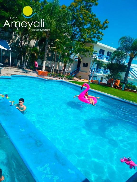 a group of people swimming in a swimming pool at Ameyali Teques in Tequesquitengo