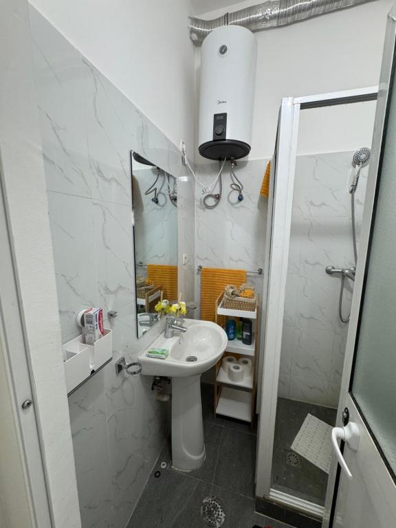 a white bathroom with a sink and a mirror at Apartamento 1 Quarto - Baixa de Luanda in Luanda