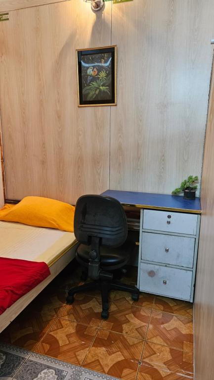 a bedroom with a desk and a bed and a chair at Sky Garden Home in Dhaka