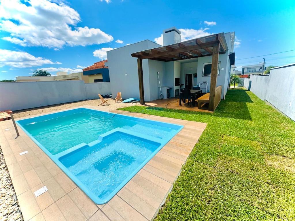 a swimming pool in the backyard of a house at Sua casa em pdetorres in Passo De Torres