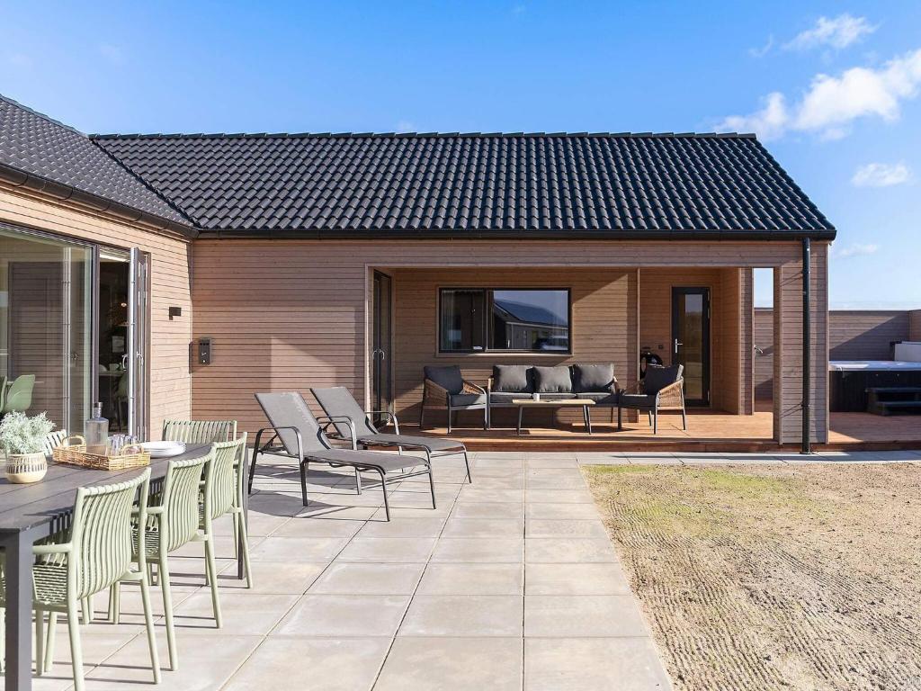 a patio with chairs and a table and a couch at 5 star holiday home in Bogense in Bogense