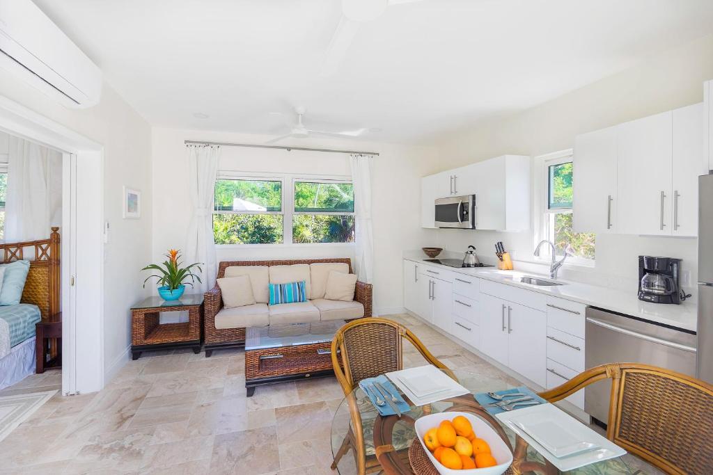 a kitchen and living room with a couch and a table at Chuchubi Cottage in Long Bay Hills