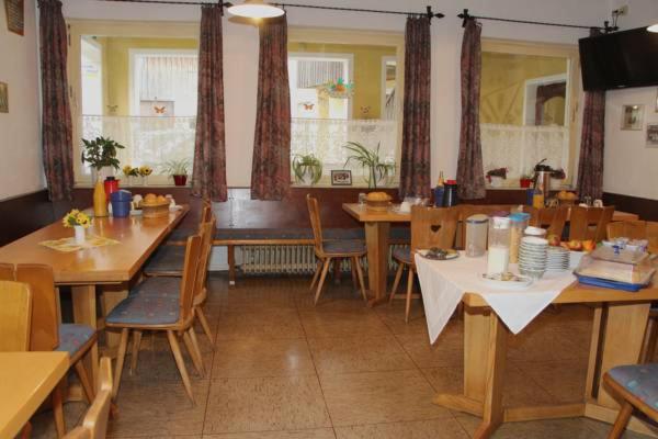 uma sala de jantar com mesas e cadeiras de madeira em Hotel Bayerischer Hof em Wiesau