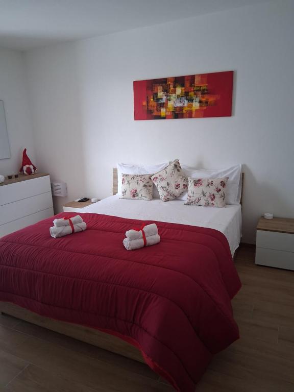 ein Schlafzimmer mit einem großen Bett mit roter Bettwäsche und Kissen in der Unterkunft A Casa di Lucia-Appartamento Deluxe in Piedimonte San Germano