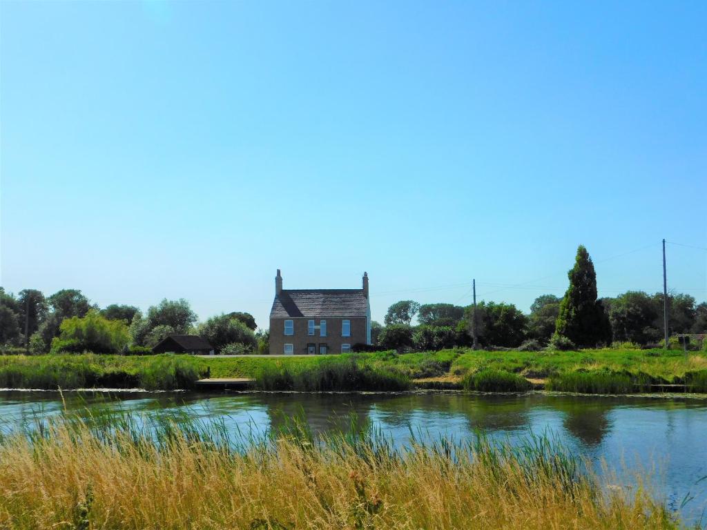 een oud huis aan de oever van een rivier bij Greenbank Cottage in Hilgay