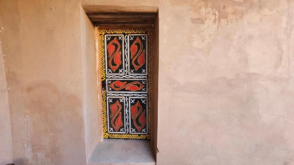 a window in the side of a building with a pattern at Dar salam in Mhamid