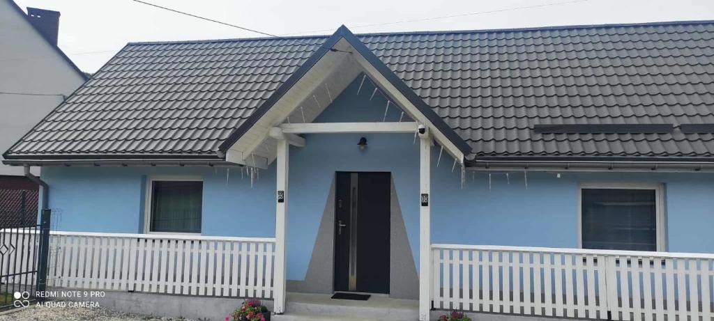 a blue house with a black roof at Noclegi W Sadzie in Rajcza