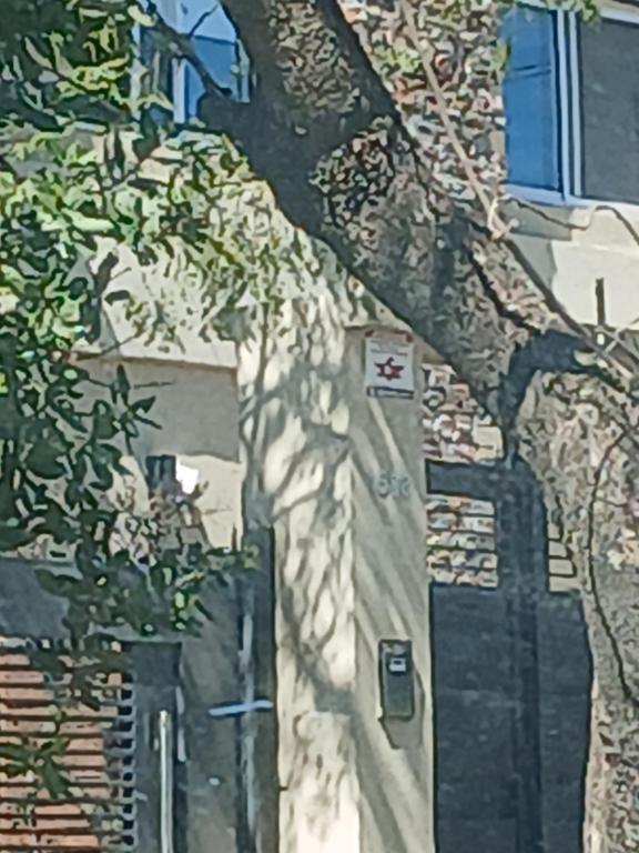 a shadow of a tree on the side of a building at Duplex en City Bell in City Bell