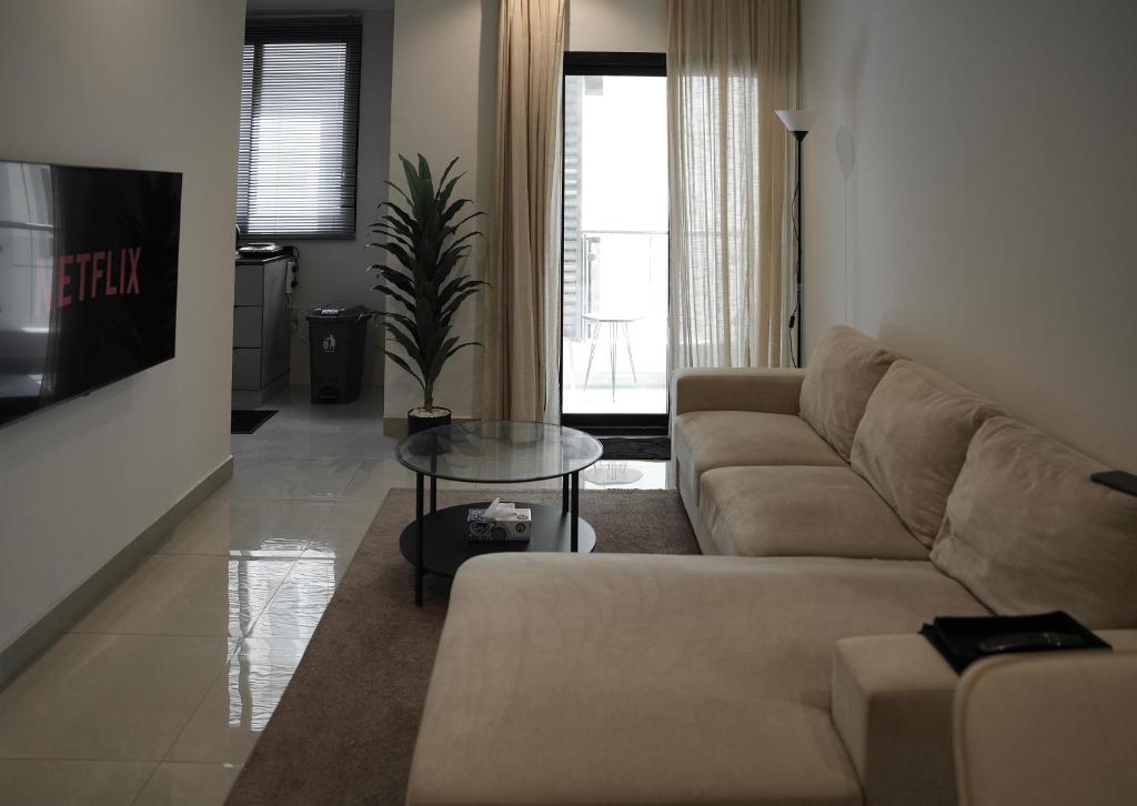 a living room with a couch and a table at Cozy Apartment in Boshar in Muscat