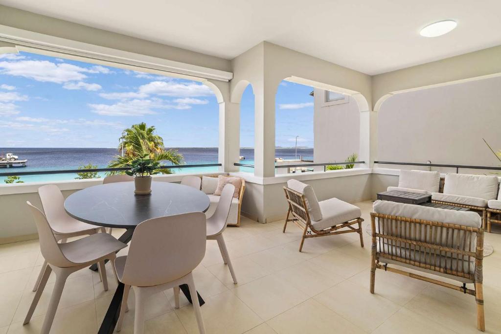 a dining room with a table and chairs and the ocean at The Shores 3 with sea views beautiful sunsets and a breezy balcony in Kralendijk