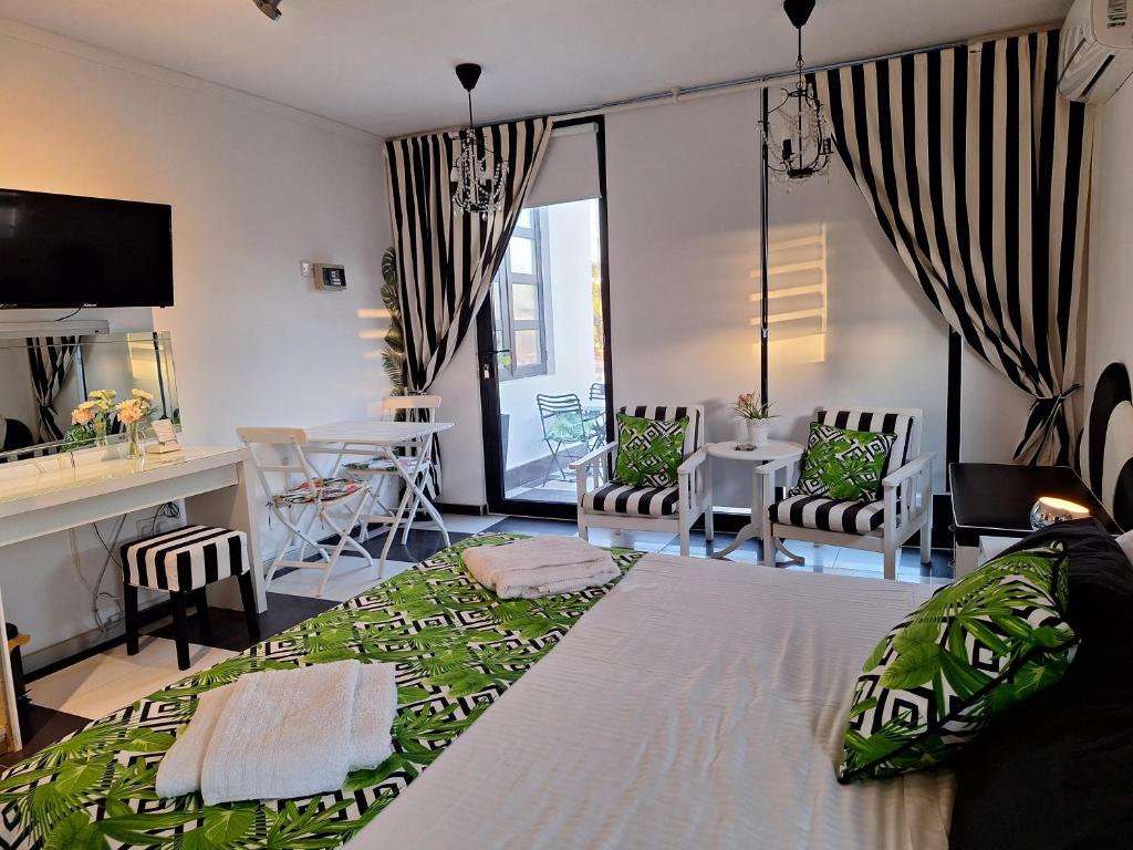 a bedroom with a bed and a table and chairs at The Pervoli Studio - Pool - Close to Beach in Larnaka