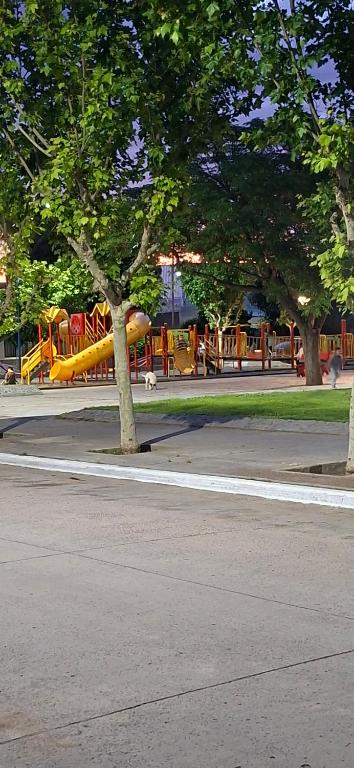 a park with a playground with a yellow slide at Apart Brumato in Catriel