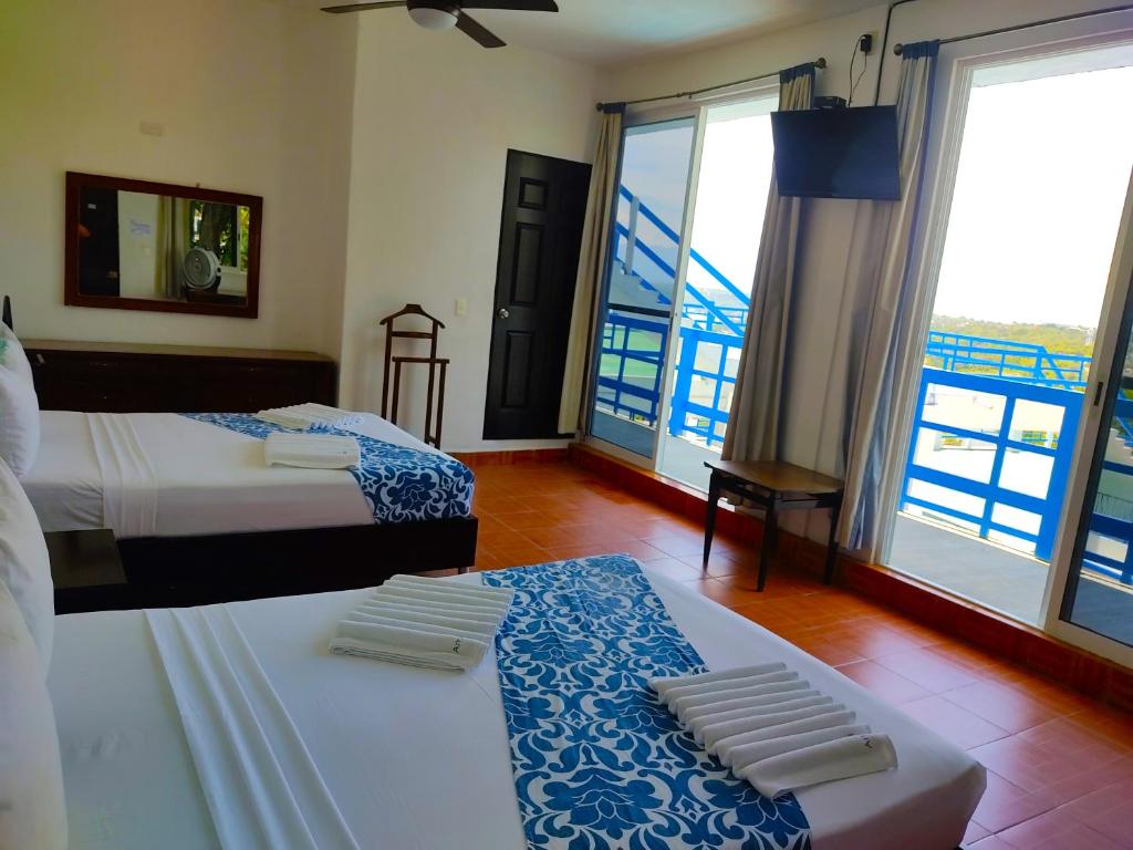 a hotel room with two beds and a balcony at Ameyali Teques in Tequesquitengo